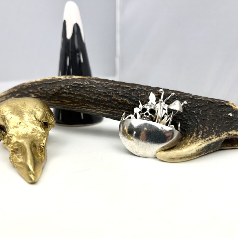 Sterling silver cup, full of floral details surround a skull.
