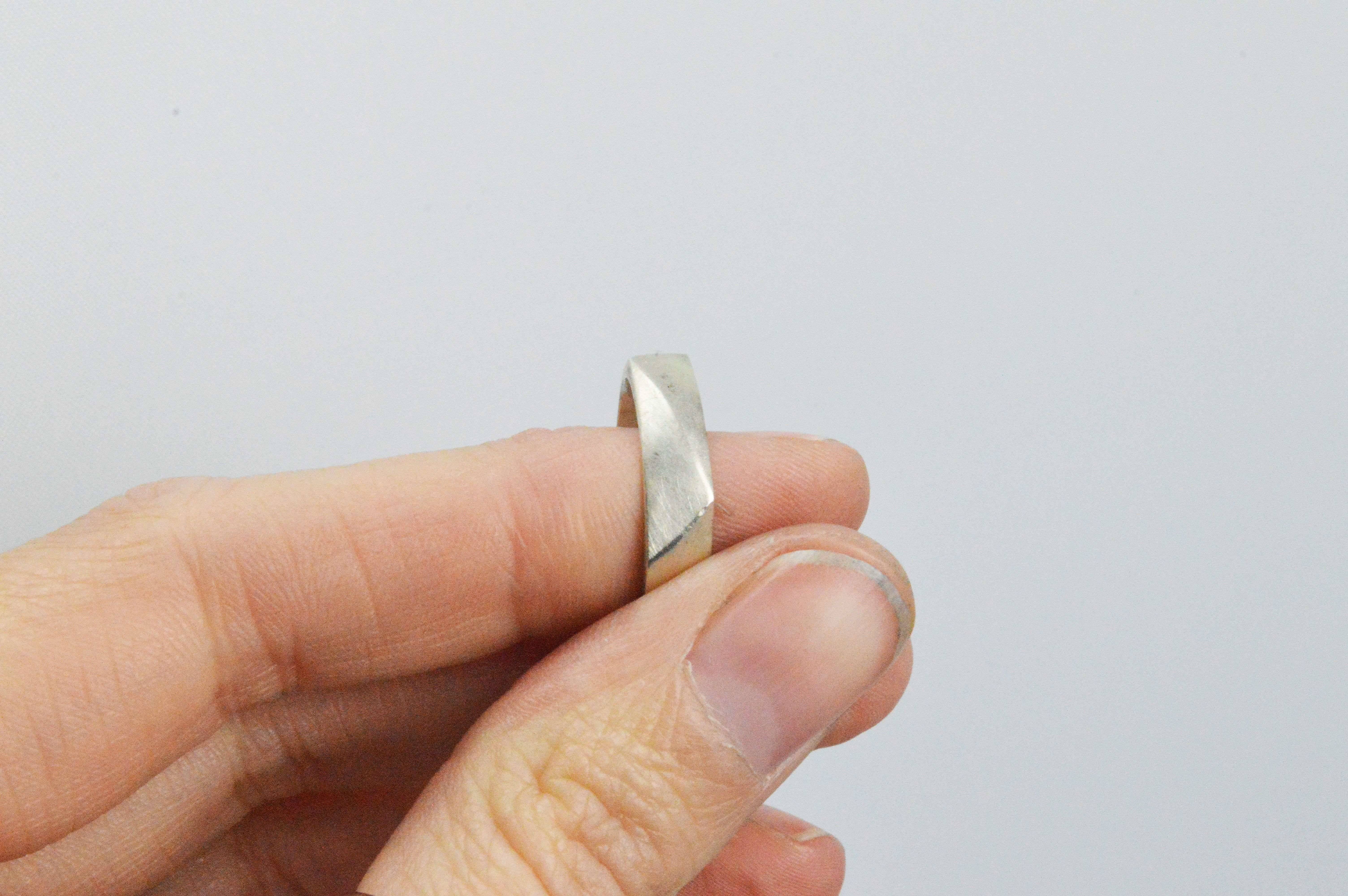 A sterling silver ring with differing angles, frosted and the edges left with a high polish