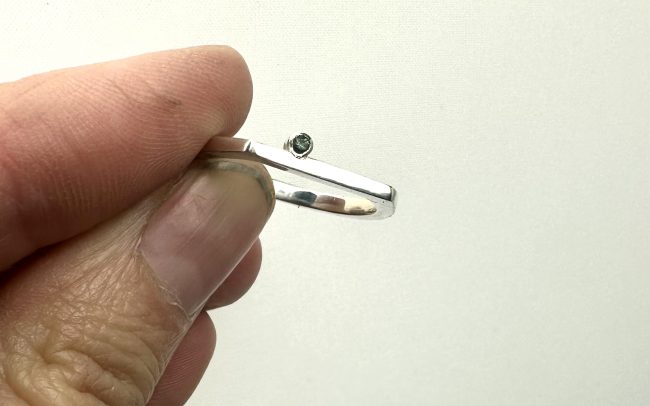 Horseshoe shaped sterling silver ring with on offset tourmaline.