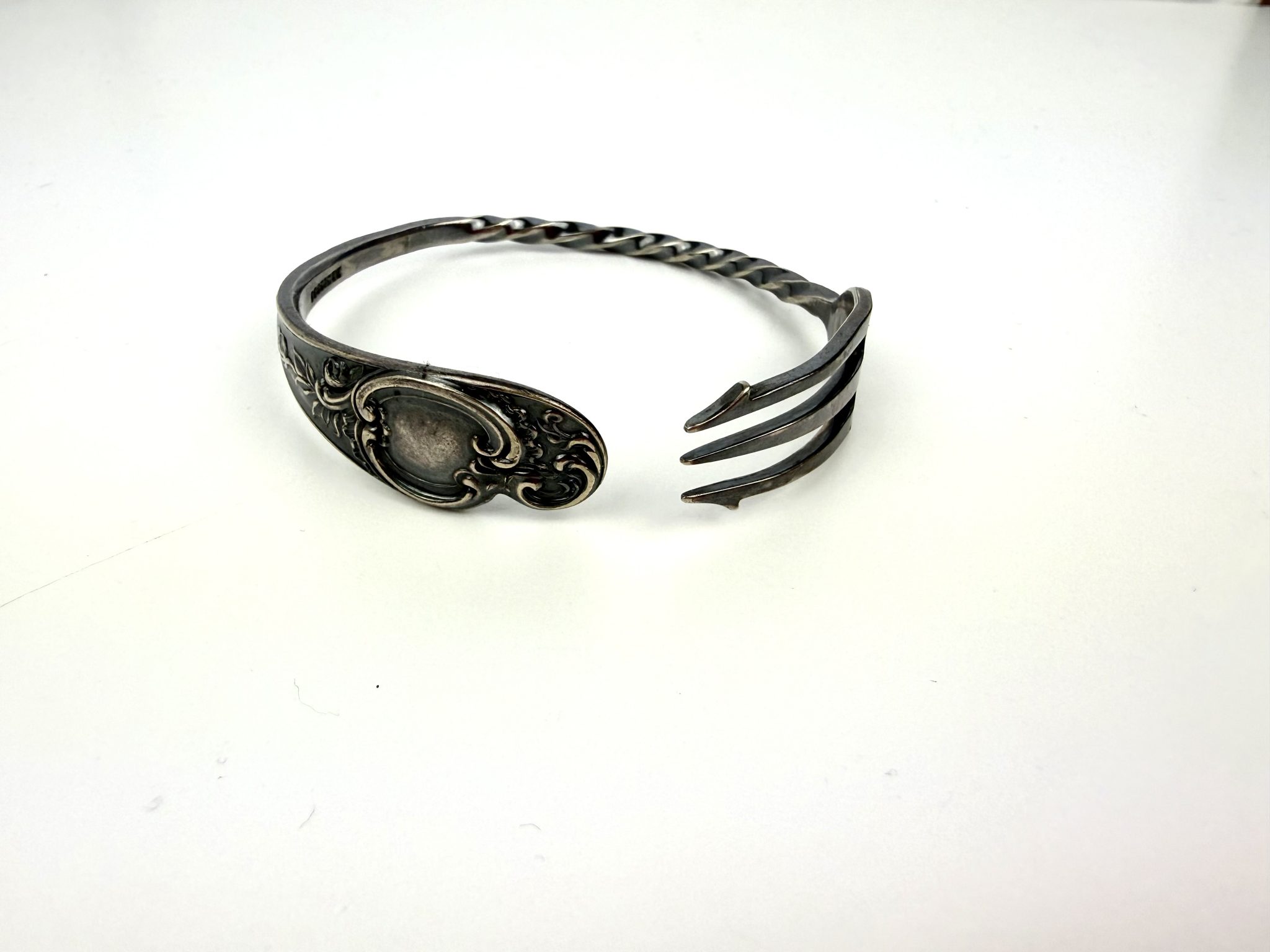 An open cuff made from a vintage pickle fork