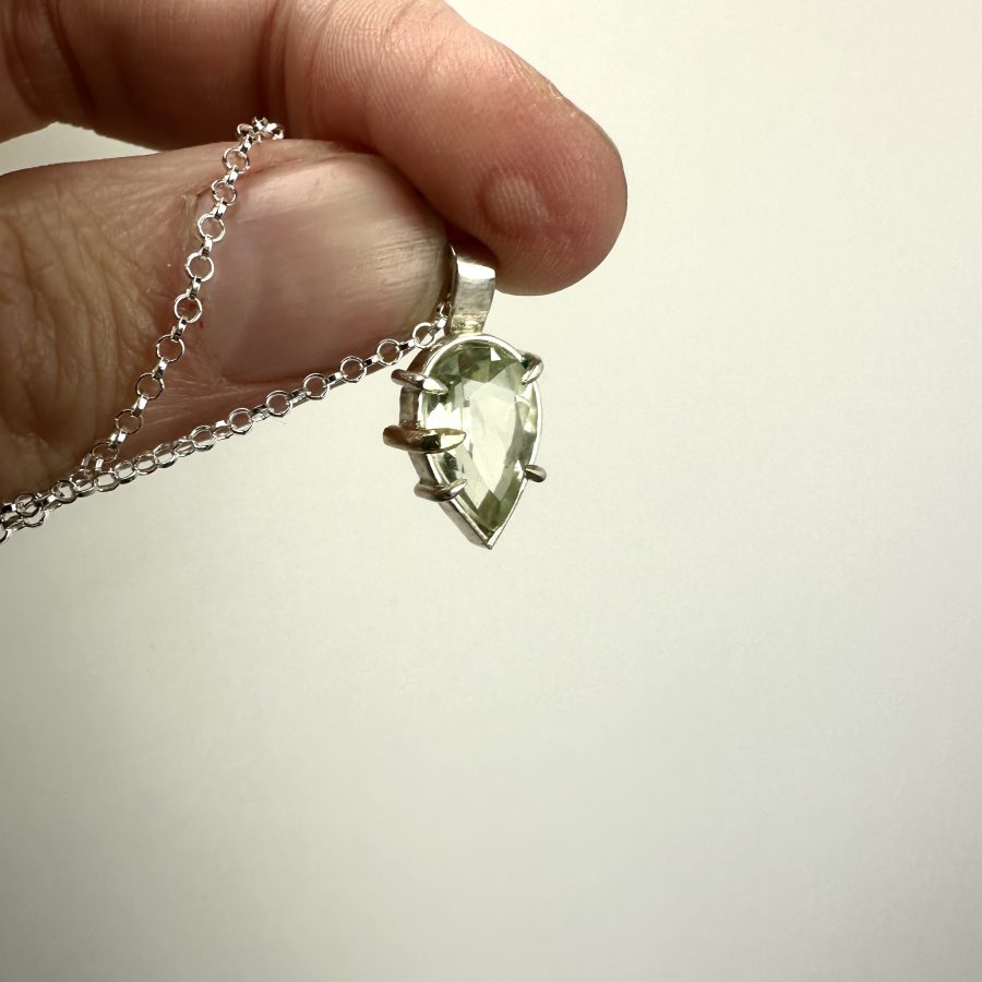 A beautiful Brazillian green amethyst teardrop wet in sterling silver with one gold claw