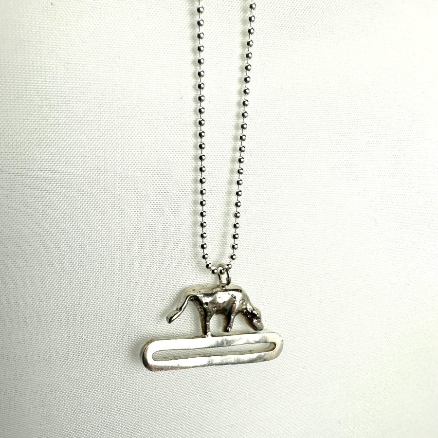 A sterling silver mini cow pendant.