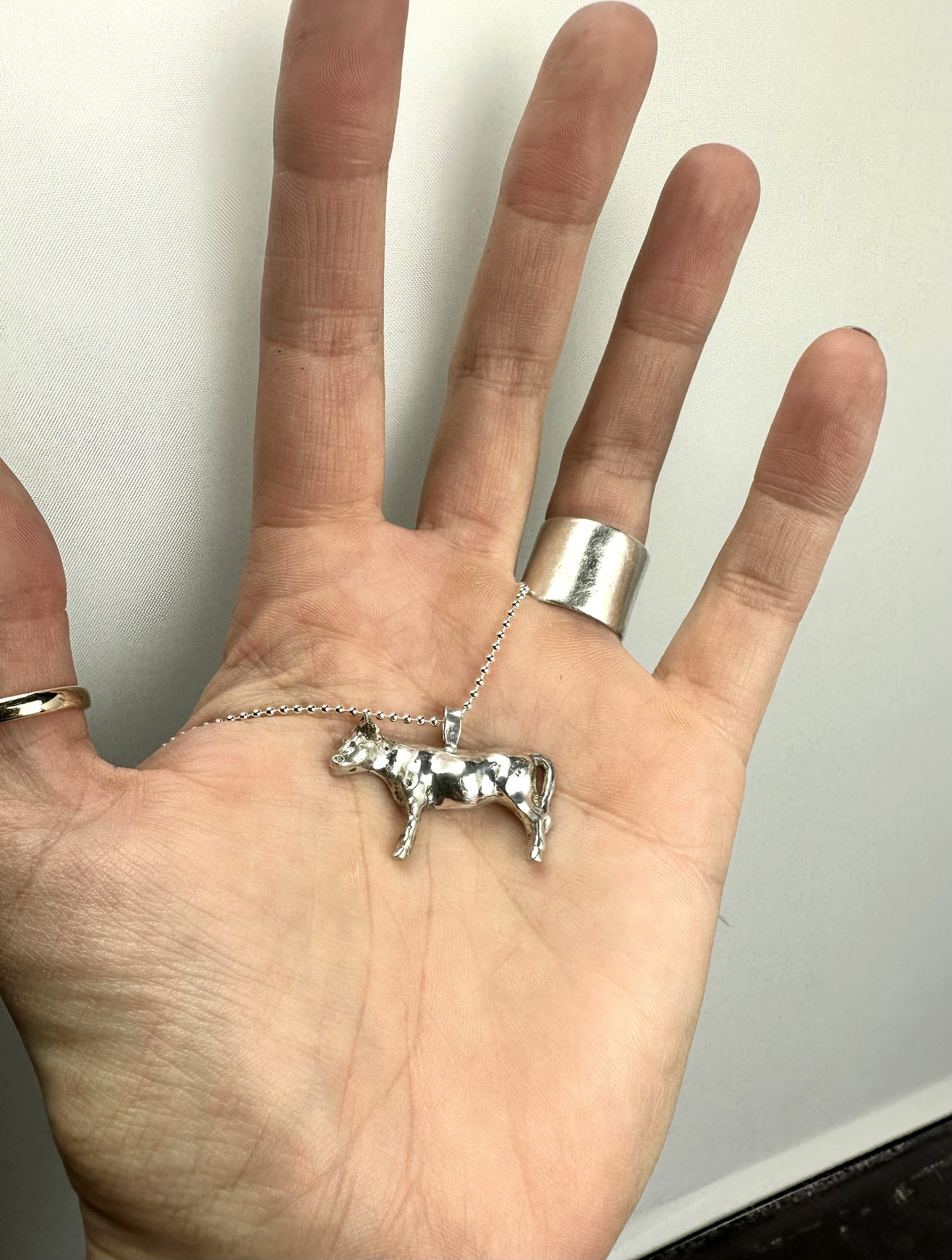 A sterling silver cow pendant.