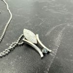 a marquise shape piece of silver cast in cuttle fish bones, with added sapphire blue CZ