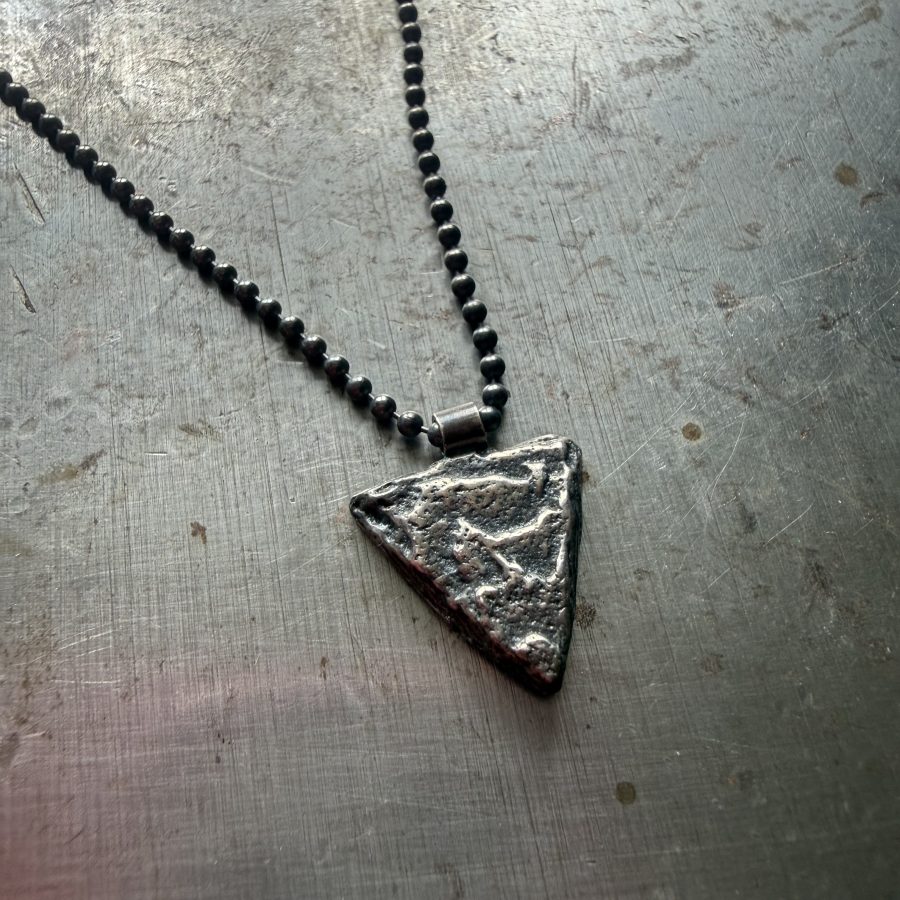 An sterling silver arrow head style pendant, cast in cuttlefish bones to add texture.