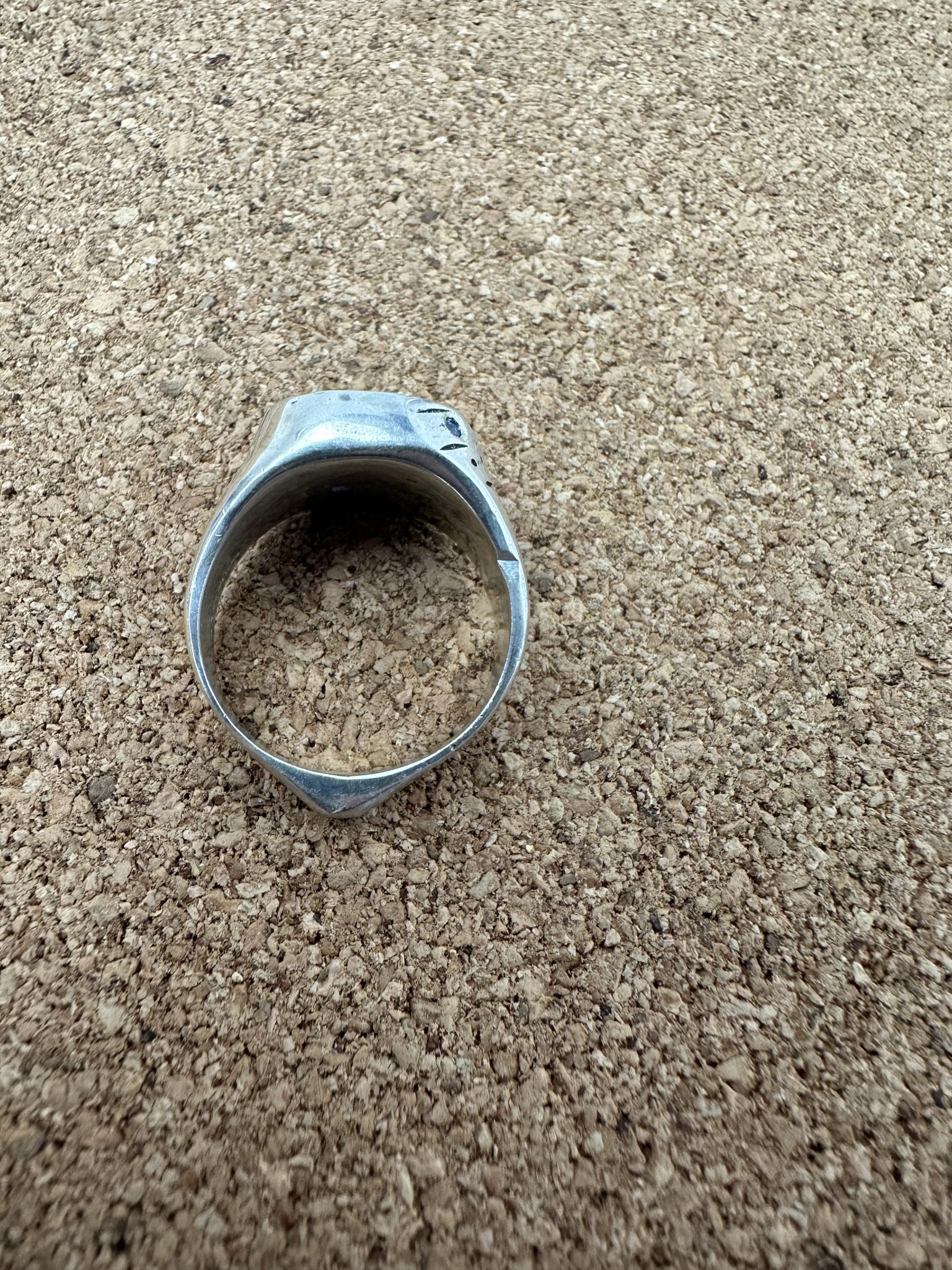 A sterling silver round signet ring, with a deep crevise handcared and scattered with sapphires.