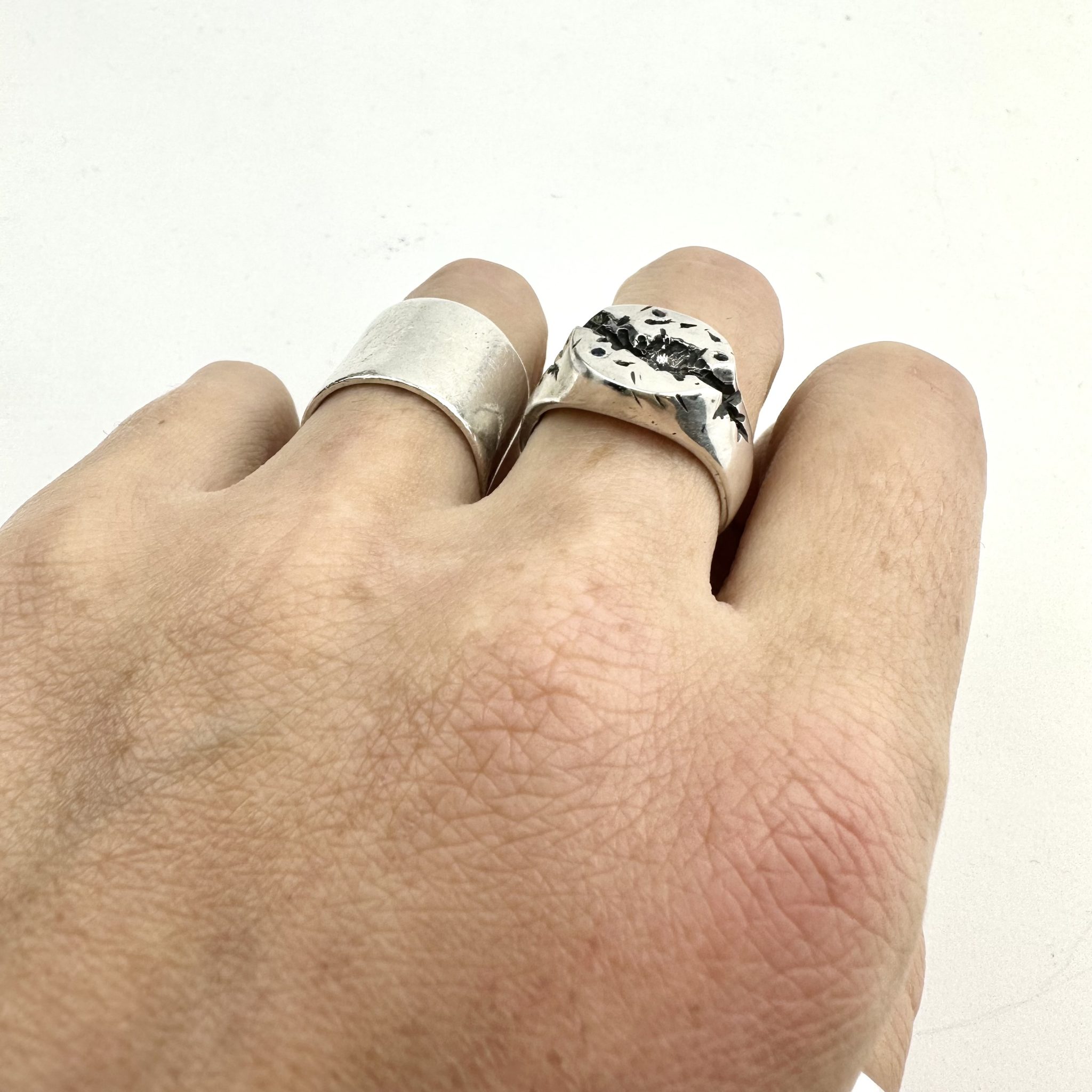 A sterling silver round signet ring, with a deep crevise handcared and scattered with sapphires.