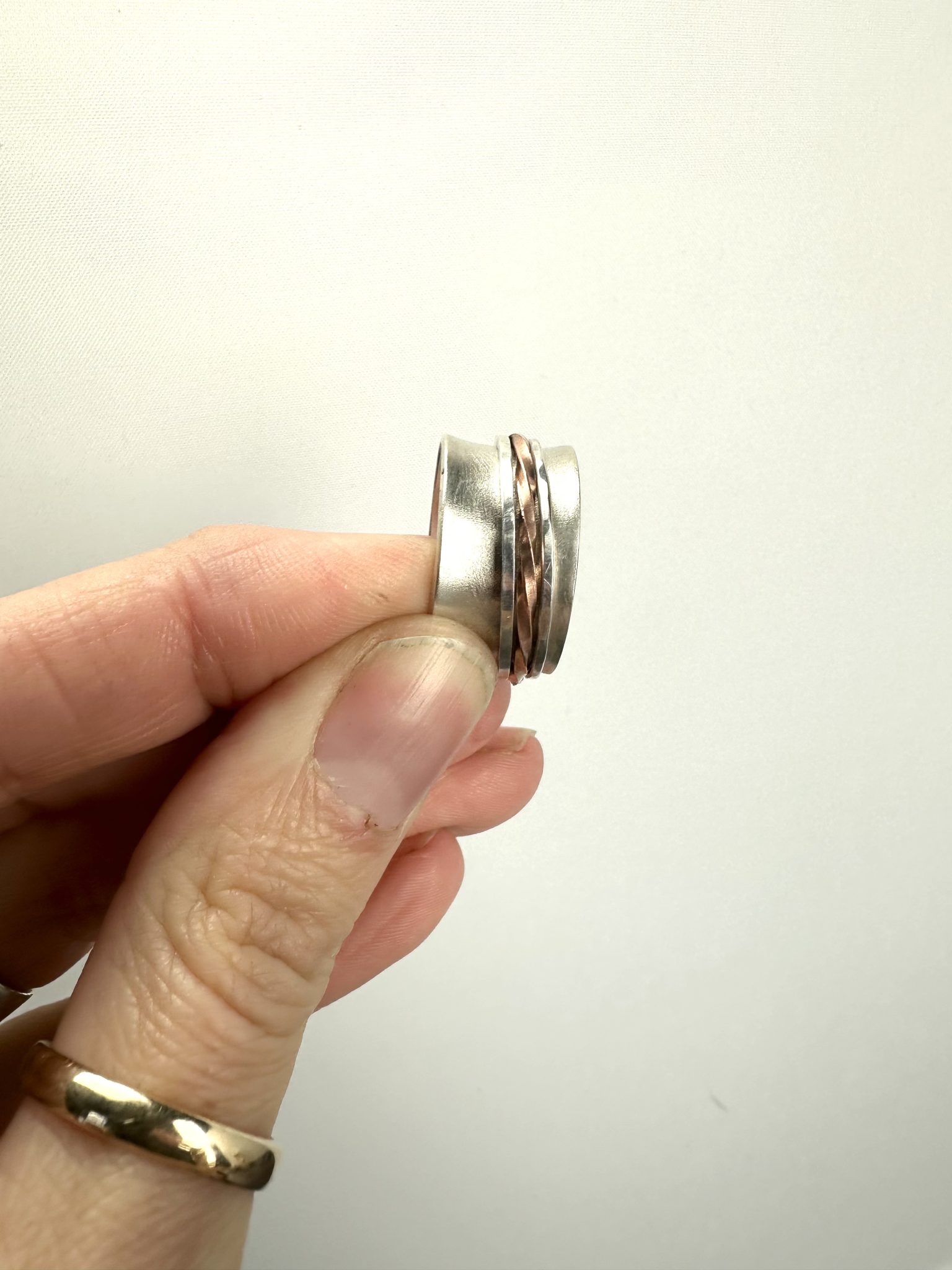 Sterling silver Spinner Ring with a frosted finish encompassed with 3 movable central bands.