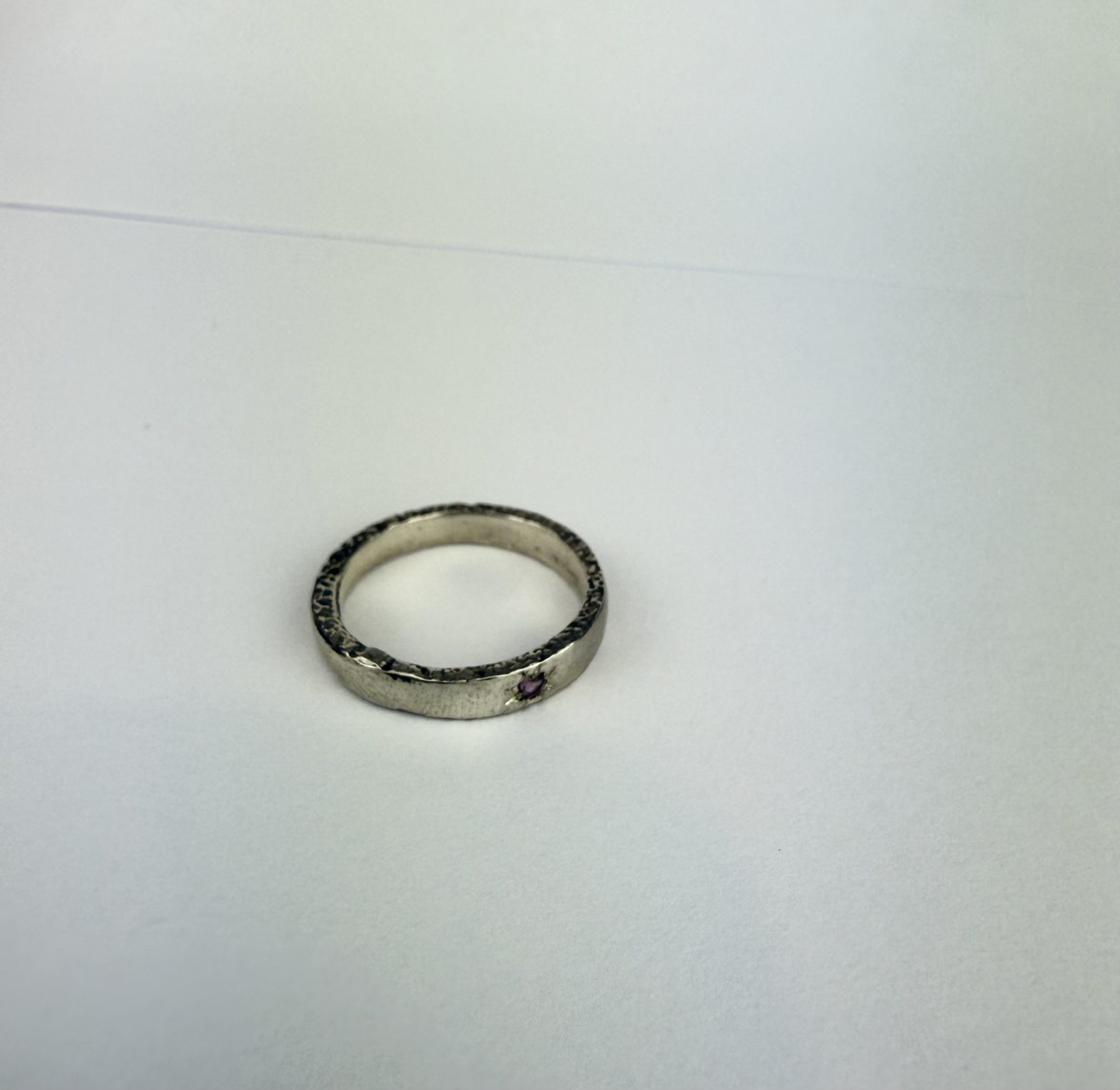 sterling silver ring, sand cast and featuring a rhodalite garnet grain set in the band.