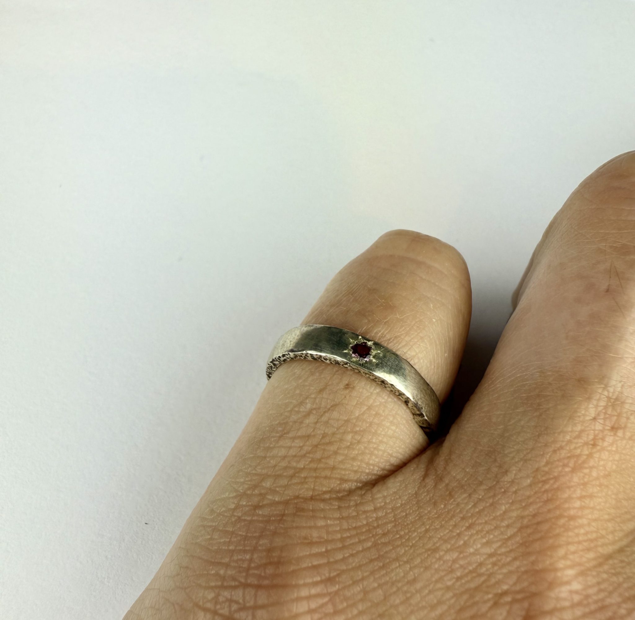 sterling silver ring, sand cast and featuring a rhodalite garnet grain set in the band.