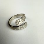 A hand forged open band sterling silver, textured wrap ring.