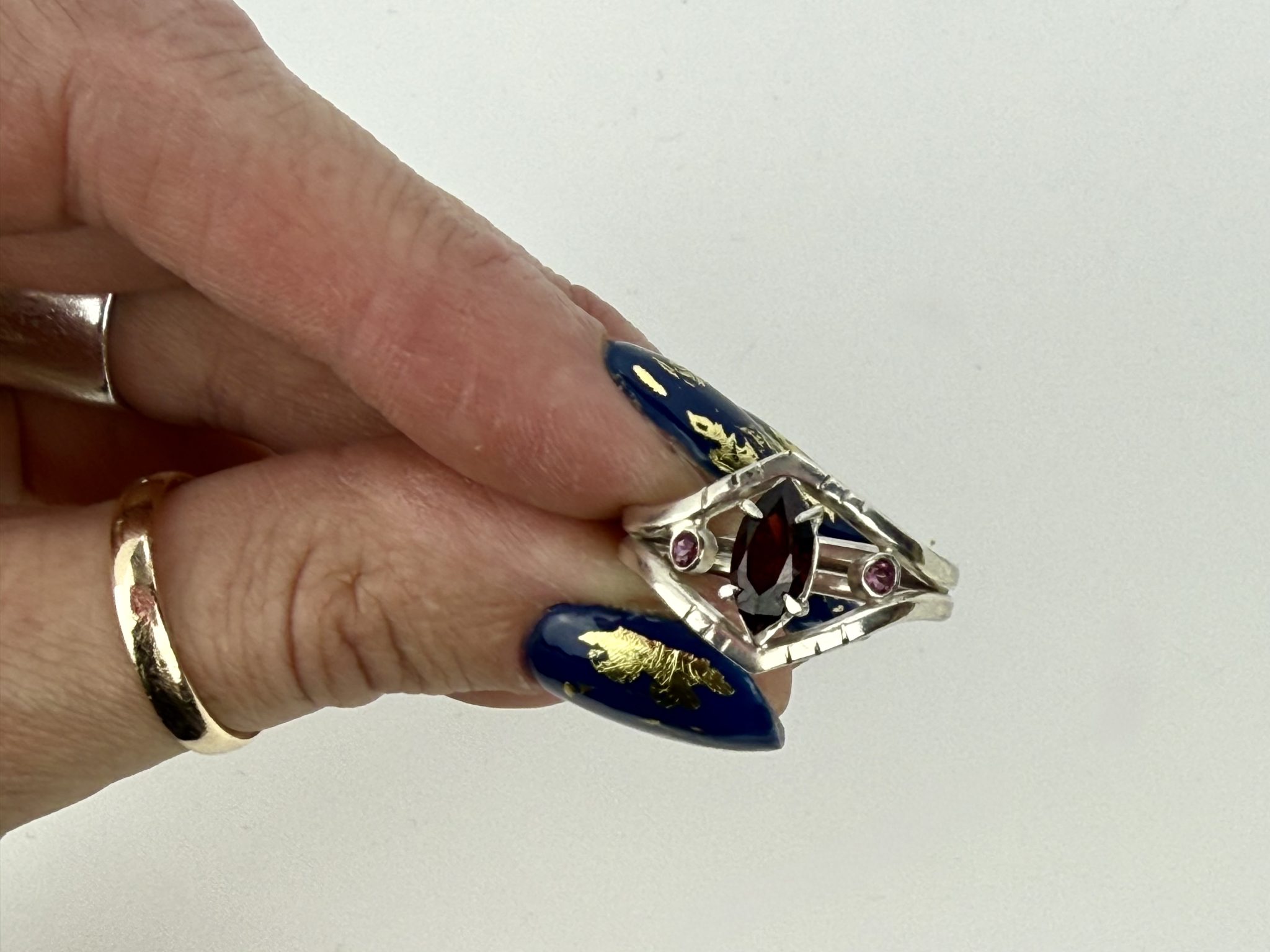 Sterling silver marquise garnet ring with rhodalite garnet accent stones and an open geometric design, bold, and perfect for a modern statement look.