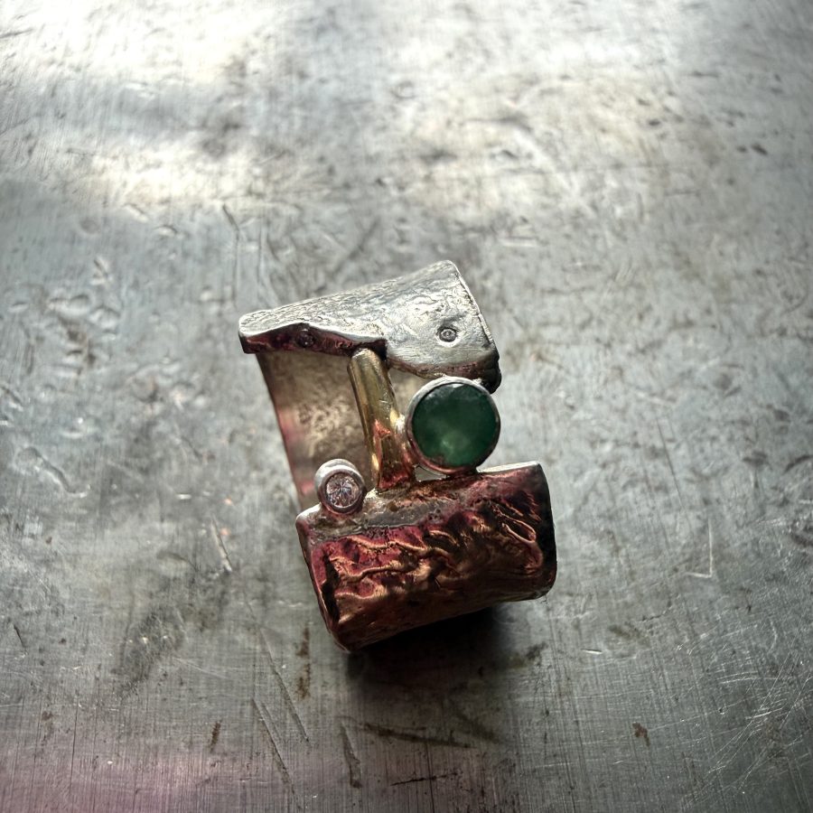 Sterling silver, textured ring band with a tube set emerals and 9ct gold accents